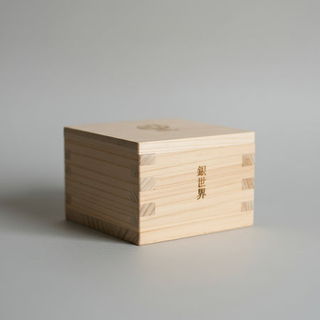 Wooden box with engraved text on a reflective surface