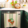 Kitchen scene with a dish towel hanging on a stove, green cabinets, and various kitchen items.